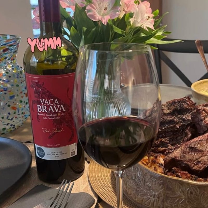 Vaca Brava Red Blend en una mesa con asado